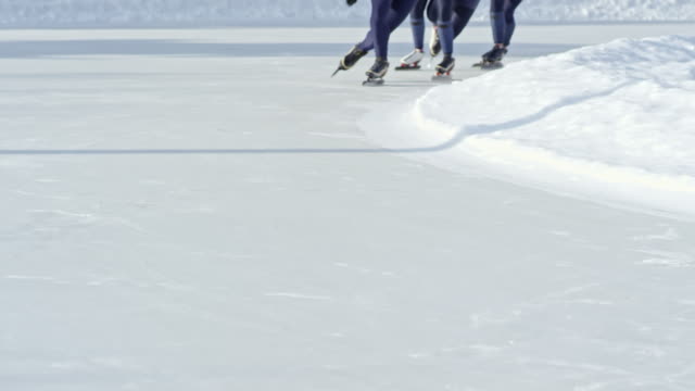 Unrecognizable-Speed-Skaters-Racing-on-Rink