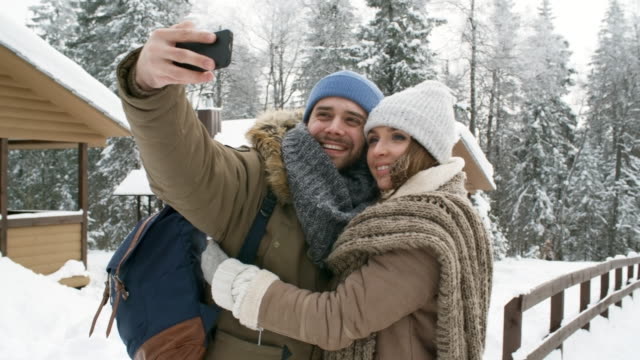 Happy-Couple-Photographing-in-Winter-Forest