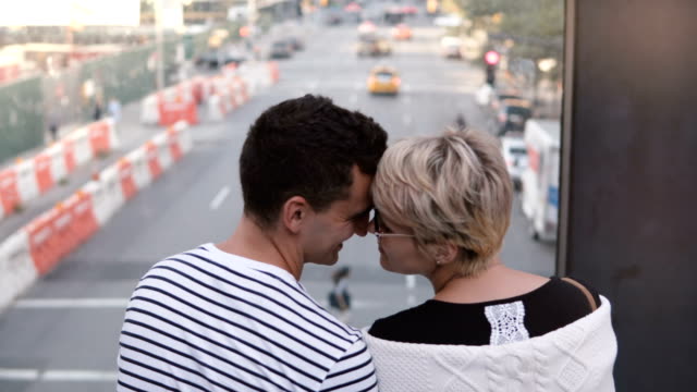 Schöne-junge-multiethnischen-romantisch-zu-zweit-stehen-auf-einer-Brücke-genießen-schöne-New-York-Street-View-und-sanft-küssen