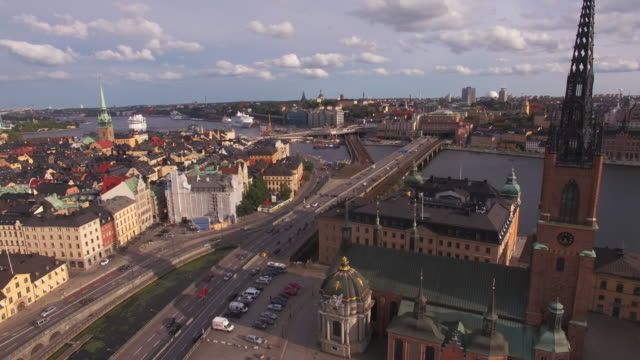 Vista-aérea-del-centro-de-la-ciudad-de-Stockholm.-Paisaje-urbano-de-Gamla-stan-y-Riddarholmen,-torre-de-la-iglesia-y-puente-con-tráfico