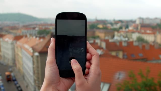 weibliche-Hände-halten-Smartphone-und-die-Fotos-von-Panorama-von-Prag