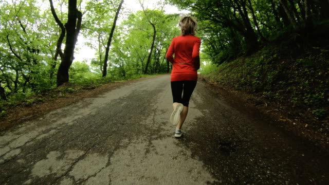 Running-girl.-Blonde-girl-doing-outdoor-sports-in-the-summer-forest.-Rear-view-slow-motion-wide-angle