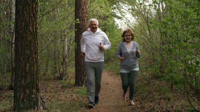 Hombre-mayor-y-mujer-para-correr-en-el-bosque