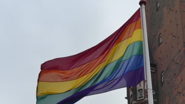 Regenbogenfahne-in-der-Innenstadt.-Regenbogenfahne-(LGBT-Bewegung)-flattert-im-Wind.-Nahaufnahme.
