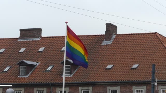 Bandera-de-arco-iris-en-el-centro-de-la-ciudad.-Bandera-arcoíris-(movimiento-LGBT)-revoloteando-en-el-viento.-De-cerca.