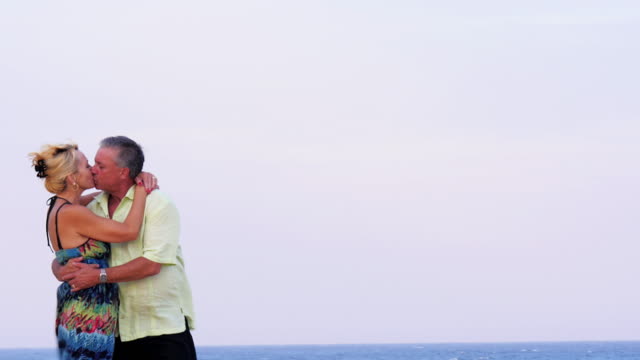 An-older-couple-kiss-on-the-beach