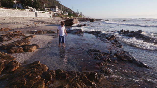 Jóvenes-chico-explorar-roca-piscina-en-la-playa-en-Ciudad-del-Cabo,-Sudáfrica