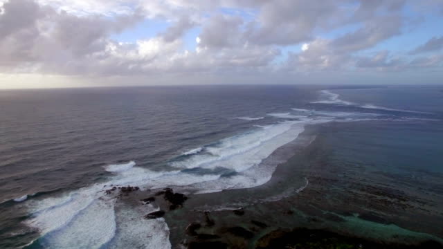 Luftaufnahme-der-Wasserlinie-der-Meere,-die-nicht-gegen-blauen-Himmel-mit-Wolken,-Insel-Mauritius-mischen