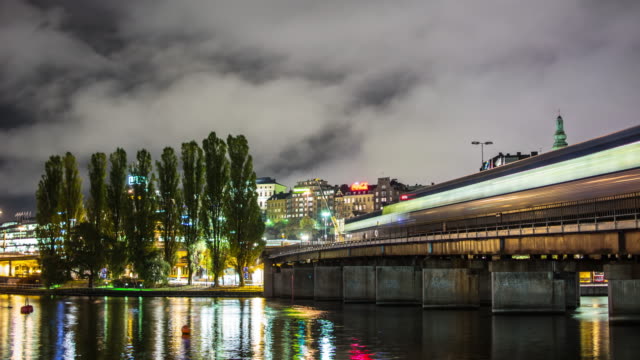 Stockholm-Stadt-Eisenbahnbrücke-und-Wasser-4K-Zeitraffer.-U-Bahn-Züge-vorbei,-Stadtbild-Hintergrund