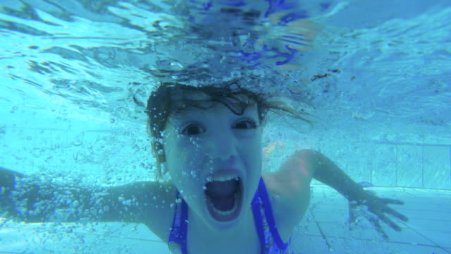 Underwater-footage-of-kids-jumping-and-diving-in-a-swimming-pool