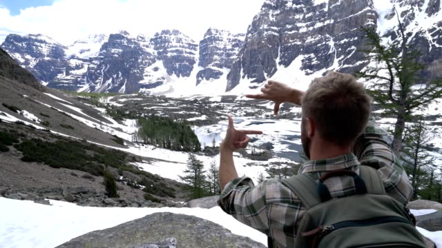 Mann-Wanderer-erreicht-Berggipfel-und-Rahmen-schöne-Berglandschaft-mit-Händen
