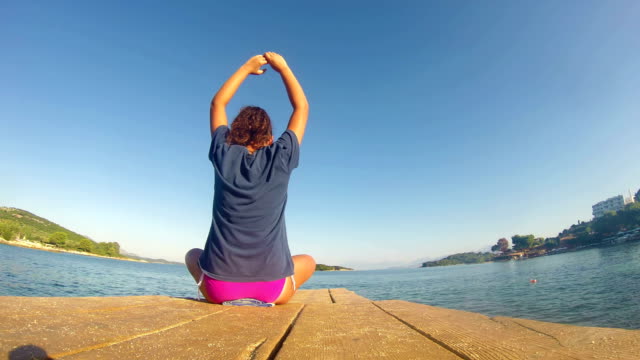 4K-beach-yoga-,-caucasian-girl-on-a-dock-wide-shoot