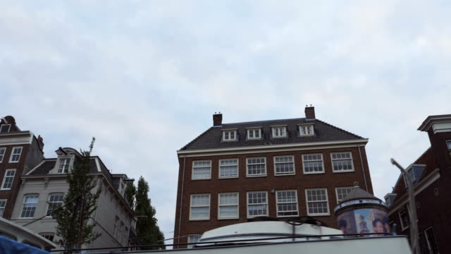 Amsterdam-Mehrfamilienhäuser-betrachtet-während-der-Fahrt-in-einem-Kanal