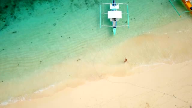 Luftbild-Drohne-schoss-der-jungen-Frau-zu-Fuß-auf-idyllischen-tropischen-Strand