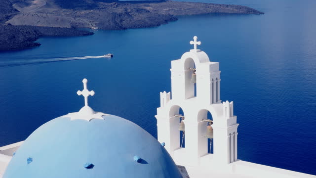boat-a-passes-behind-the-three-bells-in-fira,-santorini