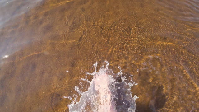 Top-view-barefoot-woman-walking-in-shallow-sea-water.-Selfie-shot.