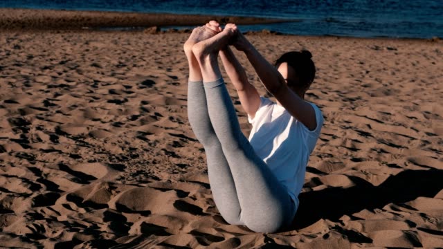 Mujer-de-estiramientos-yoga-en-la-playa-por-el-río-en-la-ciudad.-Hermosa-vista.