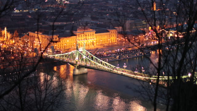 View-of-Budapest-Hungary-at-night-overlooking-the-Danube-river-with-city-lights-and-bridge.-4K-clip-of-European-tourist-city