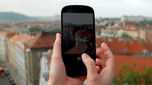 Nahaufnahme-von-weiblichen-Händen-mit-Smartphone-und-Fotografieren-der-roten-Dach-Gebäude-in-Prag
