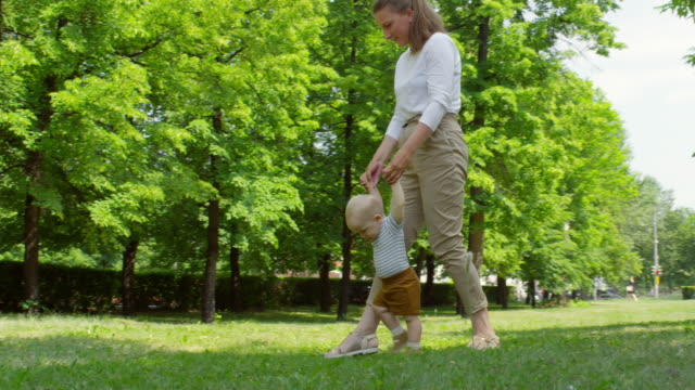 Joven-docente-bebé-a-caminar-en-el-Parque