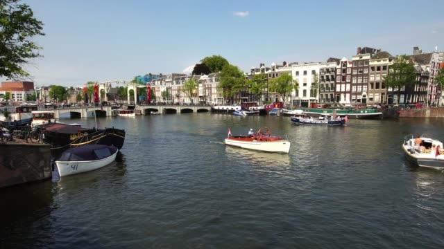 Traditionelle-Tourenboot-segelt-in-ikonische-Kanal-in-Amsterdam,-Holland-Europa