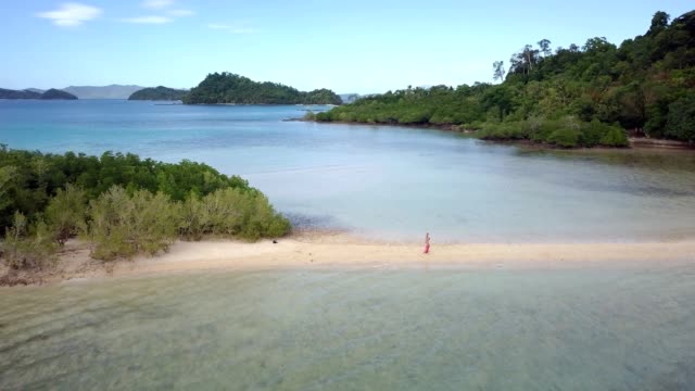 Vista-aérea-Drone-disparó-de-joven-relajante-en-playa-tropical-brazos-extendidos-disfrutando-la-libertad-en-las-Islas-Filipinas.-La-gente-viaja-concepto-de-destinos-de-vacaciones-de-lujo