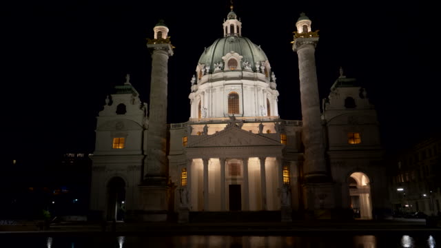 Nachtaufnahme-von-St-Karlskirche-in-einem-Pool-an-Wien-spiegelt-sich-in-der-Nähe