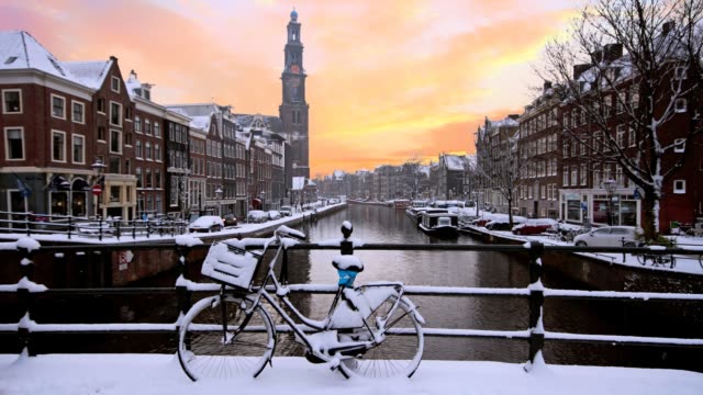 Verschneiten-Amsterdam-in-den-Niederlanden-mit-der-Westerkerk-bei-Sonnenuntergang
