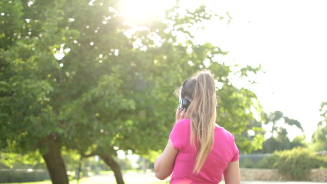 Teenager-Mädchen-hören-die-Musik-im-park,-lens-flare-Hintergrund