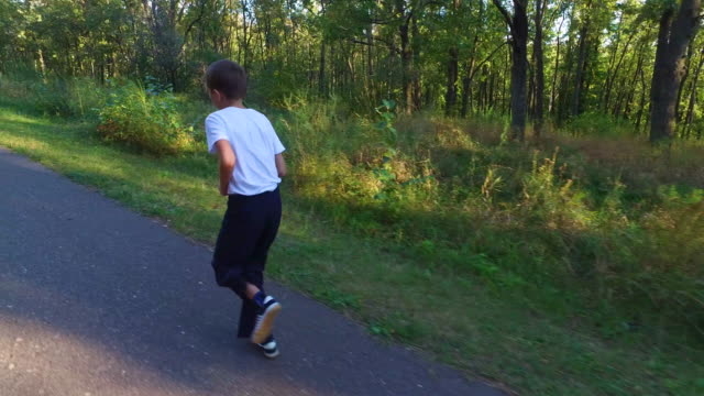 Slim-teenager-boy-is-running-on-paths-and-trails-in-the-forest.-Boy-is-trained-good-running.-Sports-in-nature.
