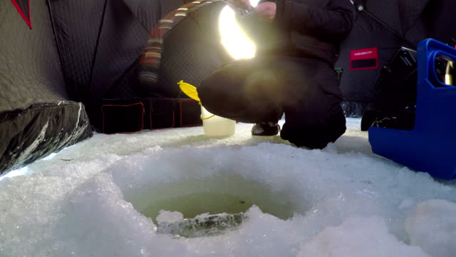 Ice-fisherman-fishing-in-tent