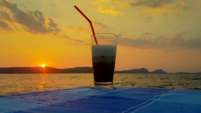 Eiskaffee-gegen-den-Sonnenuntergang-und-das-Meer.-Einen-schönen-ruhigen-Abend.
