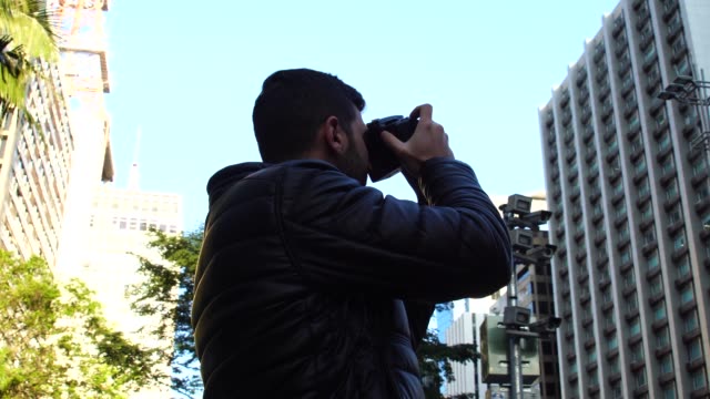 Man-photographing-the-Avenida-Paulista,-Sao-Paulo,-Brazil
