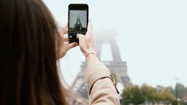 Nahaufnahme-der-jungen-Frau-fotografieren-auf-Smartphone-des-Eiffelturms.-Weibchen-mit-Handy-in-Paris,-Frankreich