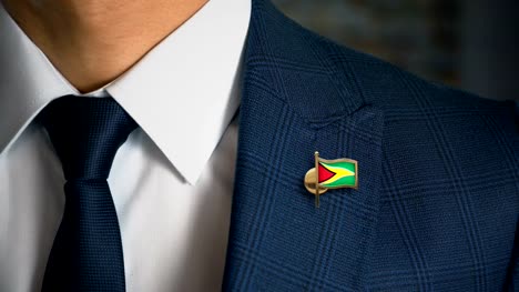 Geschäftsmann-zu-Fuß-in-Richtung-Kamera-mit-Land-Flagge-Pin---Guyana