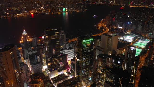 night-time-illuminated-hong-kong-cityscape-downtown-victoria-harbour-aerial-panorama-4k