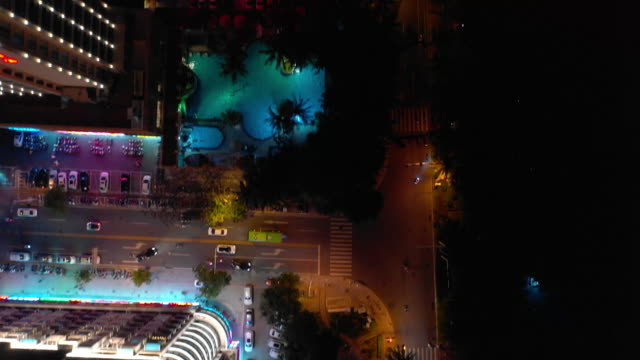 noche-tiempo-iluminación-hainan-isla-sanya-ciudad-tráfico-calle-arriba-abajo-aérea-vista-4k-china