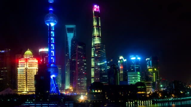 Night-time-lapse-of-the-Huangpu-river,-the-Pudong-financial-business-district,-and-the-Bund,-Shanghai-skyline,-urban-China