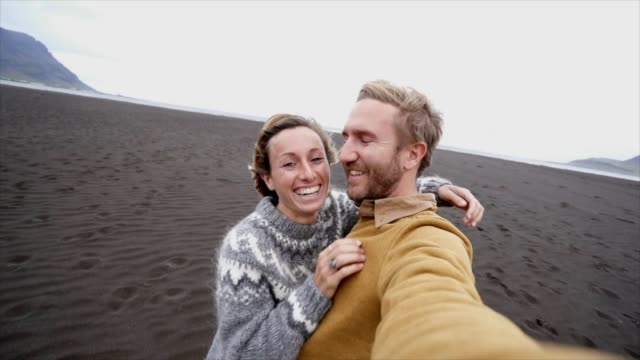 Pareja-Selfie-retrato-de-turista-en-playa-de-arena-negra-en-Islandia---cámara-lenta