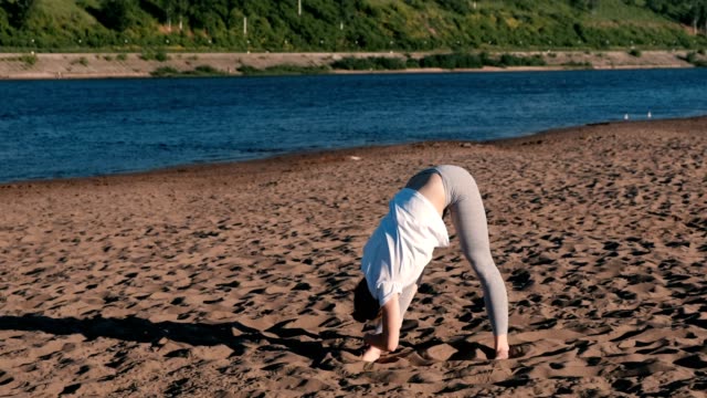 Frau,-dehnen,-Yoga-am-Strand-am-Fluss-in-der-Stadt.-Schöne-Aussicht.