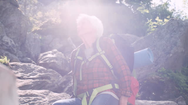 Senior-femenino-excursionista-descansando-en-las-montañas