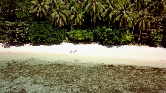 Drone-shot-aerial-view-of-Young-couple-relaxing-on-tropical-beach-in-the-Philippines-Islands.-People-travel-luxury-vacations-destinations-concept