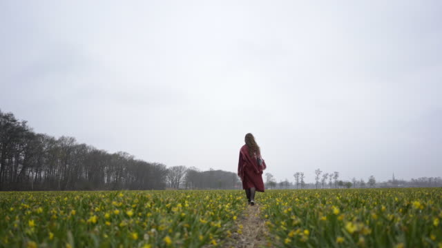 Girl-is-walking-through-a-field-of-flowers
