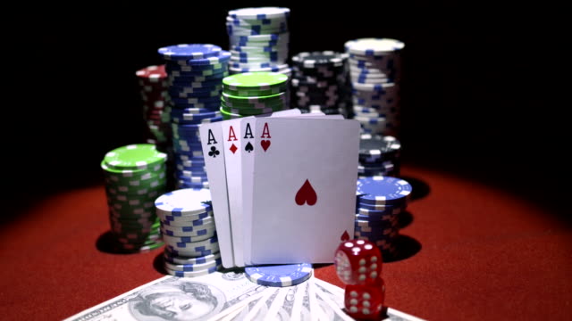Four-aces,-dollars-and-stack-of-gambling-chips-on-red-casino-table