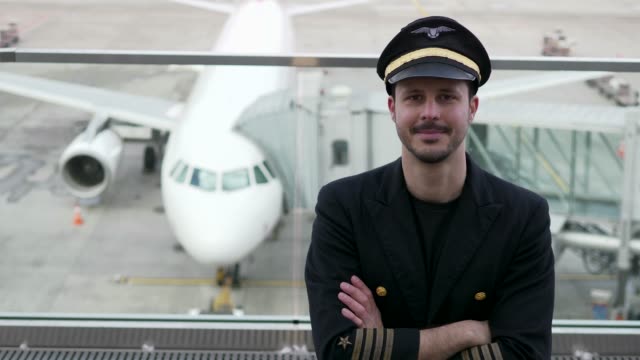 Gut-aussehende-Pilot-mit-Flugzeug-und-Flughafen-Hintergrund
