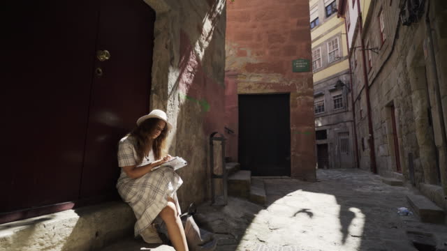 Mujer-relajante-en-una-calle-estrecha-con-mapa-de-papel