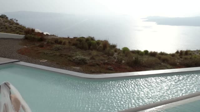 Vista-aérea-de-la-mujer-con-el-vestido-de-novia-en-la-isla-de-Santorini,-Grecia.