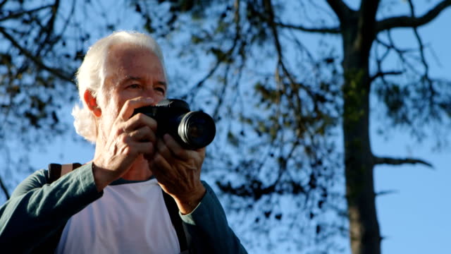 Senior-man-clicking-photos-with-digital-camera-4k