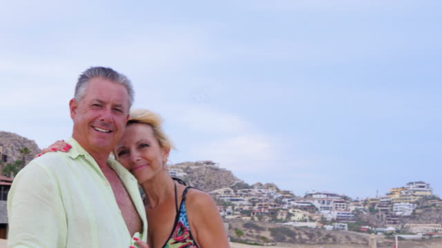 Portrait-of-an-older-couple-standing-on-the-beach