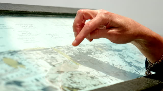 Händen-Zeigefinger-zeigt-die-Orte-auf-touristische-Karte